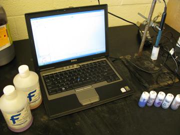 The pH testing apparatus consisting of a computer, calibration solutions, and a glass electrode.