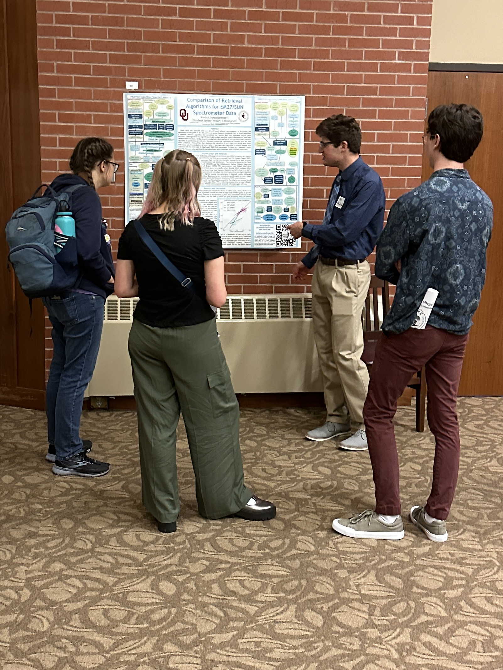A candid photo of Noah Schneiderman presenting his poster to peers.