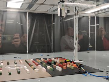 A scale model experiment under preparation inside the wind tunnel in Tom Spicer lab. Pictured in the reflection from left to right are Wesley T. Honeycutt, Elizabeth Spicer, Thomas Spicer, and Lee Fithian